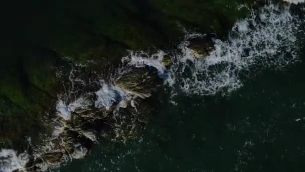 Vlny se v noci pomalu spláchnou přes skalnatý hřeben oceánu, vzdušný pohled. — Stock video