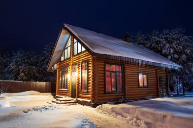 Kırsal ahşap ev, karla kaplı çam ağaçları, kar yığınları, muhteşem kış gecesi..