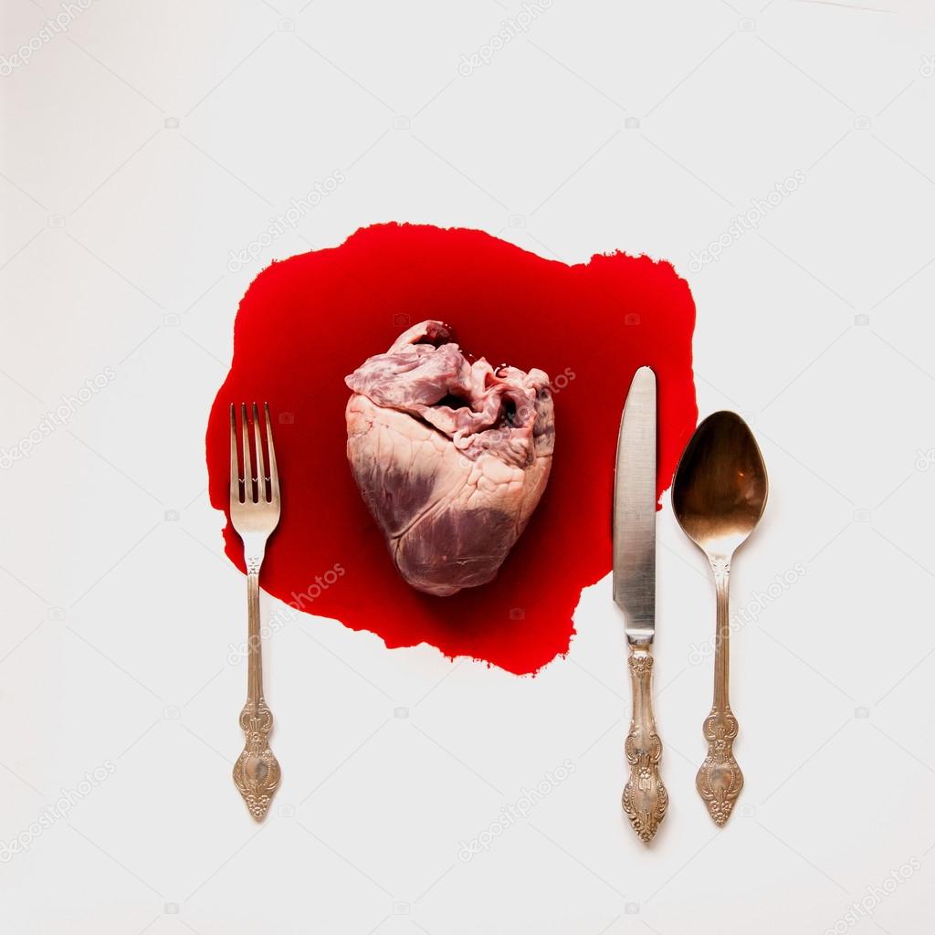 Heart and cutlery in a blood pool