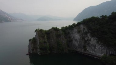 Bogn, Lombardy, İtalya 'nın Iseo Gölü' ndeki uçurum ve uçurumların insansız hava aracı görüntüsü. Dikey kayaların göle doğru süzüldüğü anlamlı bir körfez.