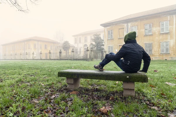 Young man seated on a bench — Stock Photo, Image