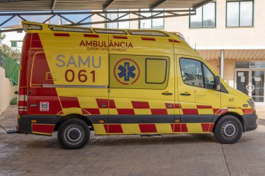 Campos, Balearic Adaları / İspanya; Kasım 2020: Campos kentindeki halk sağlığı merkezine park edilmiş ambulans. Araç sarı ve kırmızıya boyanmış.