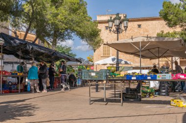 Campos, Balear Adaları / İspanya; Kasım 2020: Campos 'taki geleneksel sokak pazarında meyve ve sebze tezgahı. Covid-19 'un yeni sosyal önlemleri için yüz maskeli satıcı ve alıcılar