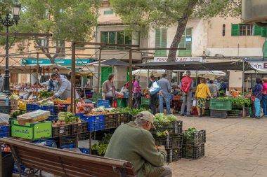 Campos, Balear Adaları / İspanya; Kasım 2020: Campos 'taki geleneksel sokak pazarında meyve ve sebze tezgahı. Covid-19 'un yeni sosyal önlemleri için yüz maskeli satıcı ve alıcılar