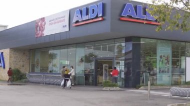 Campos, İspanya; Aralık 2020: bir Alman gıda zincirinin süpermarketine giriş. Girişteki müşteriler yemek arabaları ve yüz maskeleriyle çıkıyorlar. Yeni normal