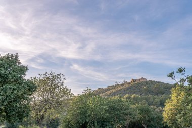İspanya 'nın Mallorca adasının iç kesimlerinde gün batımında dağın tepesindeki Montision Manastırı.