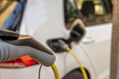Elektrikli araba bir otoparkta şarj noktasında bataryasını şarj ediyor.