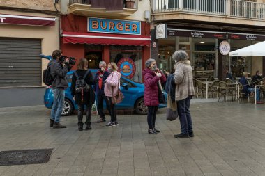 Llucmajor, İspanya; 17 Aralık 2020: Coronavirus salgını nedeniyle yüz maskesi takan gazeteciler tarafından sokaklardaki insanlarla röportaj