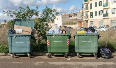 Campos, İspanya; Ocak 03 2020: Çöp torbalarıyla dolu üç yeşil çöp konteynırı