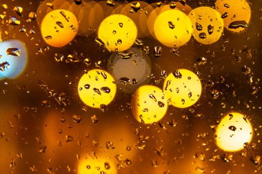 Geceleri dikkatsiz bir şehir geçmişine sahip su damlaları. Soyut kentsel resim