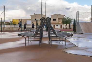 Spor salonundaki metal banklarda dikkatsiz arka planda tanınmayan insanlar koşuyor.