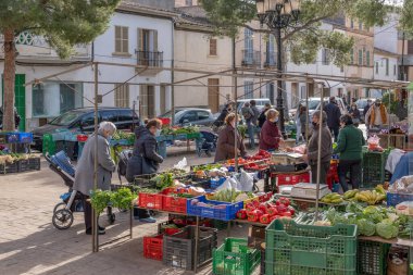 Campos, İspanya; 23 Ocak 2021: Campos kasabasındaki haftalık sokak pazarının genel görünümü. Covid-19 'un hijyenik önlemleri, güvenlik mesafesi ve nüfusun yüz maskeleri. Yeni normal kavram