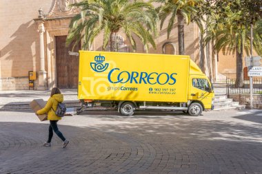 Porreres, İspanya; 22 Ocak 2021: Sarı posta kamyonu halka açık bir caddeye park edilmiş. İspanya 'da kamu posta servisi (Correos)