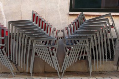 Açık havada gri metalik sandalyeler var. Restoran Covid-19 kriziyle kapandı.