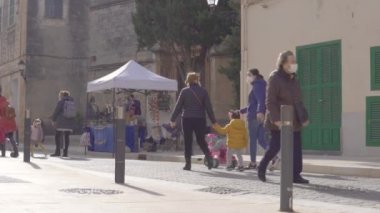 Campos, İspanya; 23 Ocak 2021: Campos kasabasındaki haftalık sokak pazarının genel görünümü. Covid-19 'un hijyenik önlemleri, güvenlik mesafesi ve nüfusun yüz maskeleri. Yeni normal kavram