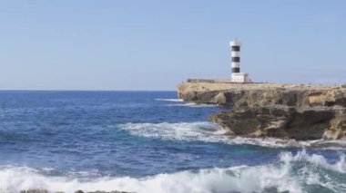 Güneşli ve dolambaçlı bir günde Colonia de Sant Jordi deniz feneri. İspanya 'nın Mallorca adasının kayalık sahillerinde Akdeniz