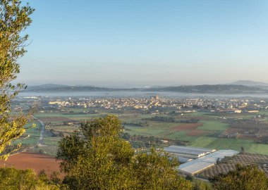 Güneş ve sisli Mallorca adasının iç kısımlarında güneşin doğuşunun havadan görünüşü. Görkemli manzara ve ışık. Porreres kasabasının havadan görünüşü