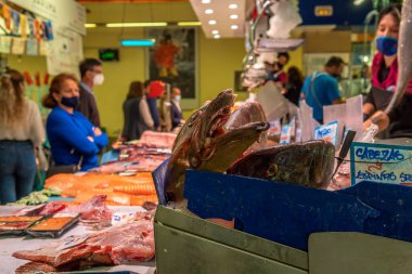 Palma de Mallorca, İspanya; 23 Nisan 2021: Alışverişçiler ve satıcılar geleneksel Mercado del Olivar 'da bir balık pazarında yüz maskesi takıyorlar. Covid-19 salgını sırasında yeni normallik