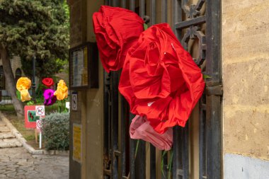 Kitap Günü ya da Sant Jordi 'nin Günü kutlamaları için şehir metal kapısına asılı kağıt güller.