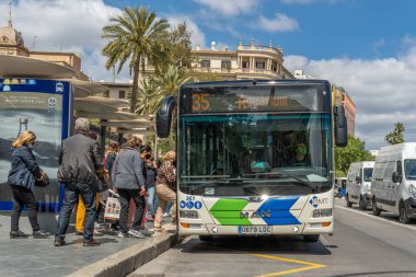 Palma de Mallorca, İspanya; 23 Nisan 2021: Palma de Mallorca Plaza Espana 'da otobüs durağı. Coronavirüs salgınından dolayı yüz cerrahisi maskesi takan yolcular ve sürücüler. Yeni normallik kavramı