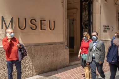 Palma de Mallorca, İspanya; 23 Nisan 2021: Joan March Çağdaş Sanat Müzesi 'nin ana cephesi. Koronavirüs salgınından dolayı yüz maskesi takan yayalar. Yeni normallik kavramı
