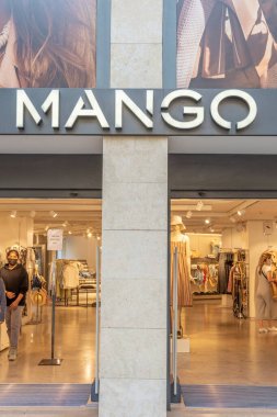 Palma de Mallorca, Spain; april 23 2021: Shop window of a clothing and accessories store belonging to the multinational Mango, with people wearing face masks due to the Coronavirus epidemic