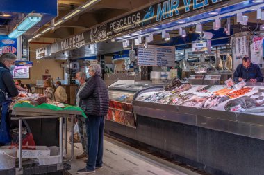 Palma de Mallorca, İspanya; 23 Nisan 2021: Alışverişçiler ve satıcılar geleneksel Mercado del Olivar 'da bir balık pazarında yüz maskesi takıyorlar. Covid-19 salgını sırasında yeni normallik