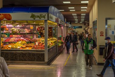 Palma de Mallorca, İspanya; 23 Nisan 2021: Mercado del Olivar 'ın içinde, meyve ve sebze bölümünde. Coronavirus salgını yüzünden yüz cerrahisi maskeli müşteriler ve piyango satıcısı.