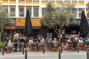 Palma de Mallorca, İspanya; 19 Mayıs 2021: Palma de Mallorca 'nın tarihi merkezinde Coronavirus yüzünden maske takan müşteriler ve işçiler ile bir kafeterya terası