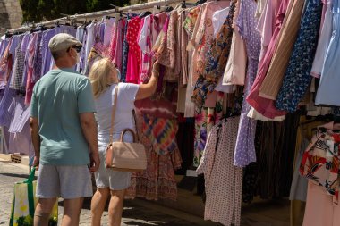 Campos, İspanya; 12 Haziran 2021: Majorcan 'ın Campos kasabasında haftalık giysi ve aksesuar pazarı. Coronavirus salgını yüzünden yüz maskesi takan müşteriler. Yeni normallik kavramı