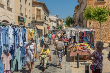 Campos, İspanya; 12 Haziran 2021: Majorcan 'ın Campos kasabasındaki haftalık sokak pazarında kıyafet tezgahları. Yüz maskesi takan insanlar. Koronavirüs salgını. Yeni normallik kavramı
