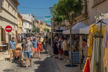 Campos, İspanya; 12 Haziran 2021: Majorcan 'ın Campos kasabasındaki haftalık sokak pazarında kıyafet tezgahları. Yüz maskesi takan insanlar. Koronavirüs salgını. Yeni normallik kavramı