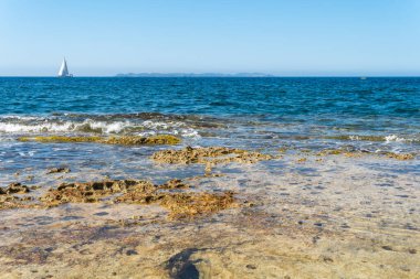Gündoğumunda Mallorca adasının güney kıyısında Akdeniz 'de bir yelkenli ve arka planda Cabrera adası ile birlikte