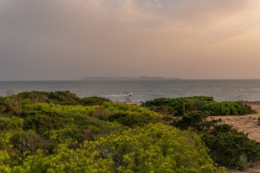 Günbatımında Mallorca adasının güney kıyısında Cabrera adası arka planda.