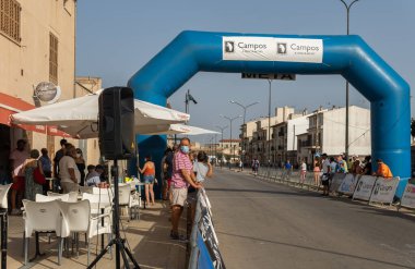 Campos, İspanya; 14 Ağustos 2021: Majorcan kasabası Campos 'un koruyucu azizesinin kutlamaları kapsamında gün batımında bisiklet yarışması. Coronavirus salgınını azaltmak için gerekli önlemler.