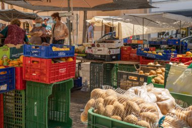 Campos, İspanya; 12 Haziran 2021: Campos kasabasındaki Mallorca adasının tipik yiyecek pazarı. Coronavirus salgını yüzünden yüz maskesi takan müşteriler ve satıcılar. Yeni normal
