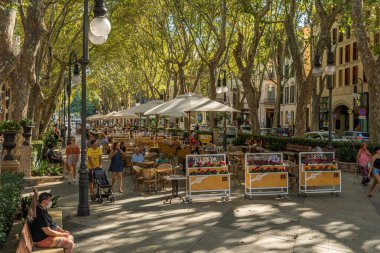 Palma de Mallorca, İspanya; 10 Eylül 2021: Paseo del Borne 'un günbatımında Palma de Mallorca' nın tarihi merkezindeki genel manzarası. Müşterilerin içki içtiği bir kafe terası.