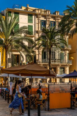 Palma de Mallorca, İspanya; 10 Eylül 2021: Plaza de la Lonja, Palma de Mallorca 'nın tarihi merkezi. Kafelerin teraslarında içki içen turistler.