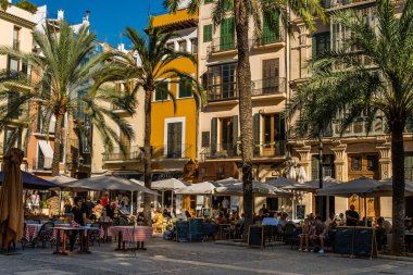 Palma de Mallorca, İspanya; 10 Eylül 2021: Plaza de la Lonja, Palma de Mallorca 'nın tarihi merkezi. Kafelerin teraslarında içki içen turistler.