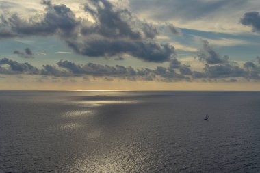 Akdeniz 'in deniz manzarası. Gün batımında bulutlar ve sularında yüzen bir gemi. İspanya 'nın Mallorca adasından gün batımının muhteşem manzarası