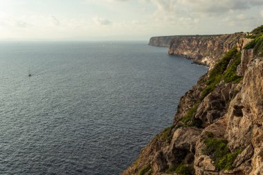Güneşli bir sabahta Mallorca adasının kayalık sahil manzarası ve kayalıklarda dalgalar. Doğa arkaplan resmi