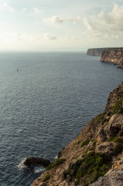 Güneşli bir sabahta Mallorca adasının kayalık sahil manzarası ve kayalıklarda dalgalar. Doğa arkaplan resmi