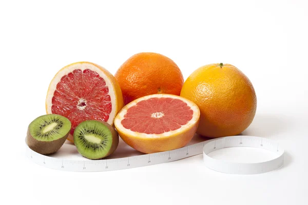 Grupo de frutas tropicais e fita métrica em polegadas sobre branco — Fotografia de Stock