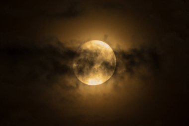 Dolunay dramatik bulutlarda parlıyor.