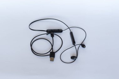 Kulaklıkla kablosuz, beyaz arka planda şarj edilmiş usb kablosu..