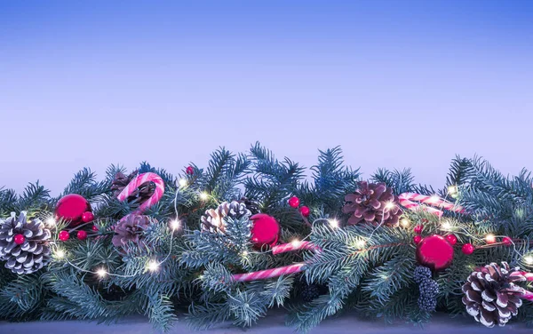 Гирлянда Рождественскими Украшениями Ветви Сосны Леденцы Шишки Красные Шарики Огни — стоковое фото