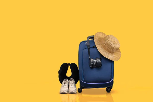 蓝色轮式手提行李和黄色背景下的基本旅行物品 — 图库照片
