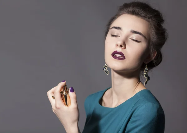 Girl holding a bottle of perfume — Stock Photo, Image