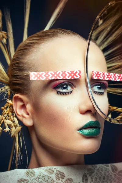 Fashion portrait of a girl with ears in her hair and the national pattern of the eyebrows and mirror and towel — Stock Photo, Image