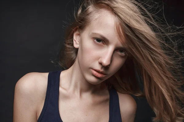 Portret van het gezicht van jonge blonde vrouw zonder make-up. Zwarte achtergrond. Natuurlijke beeld. Wazig haar. — Stockfoto